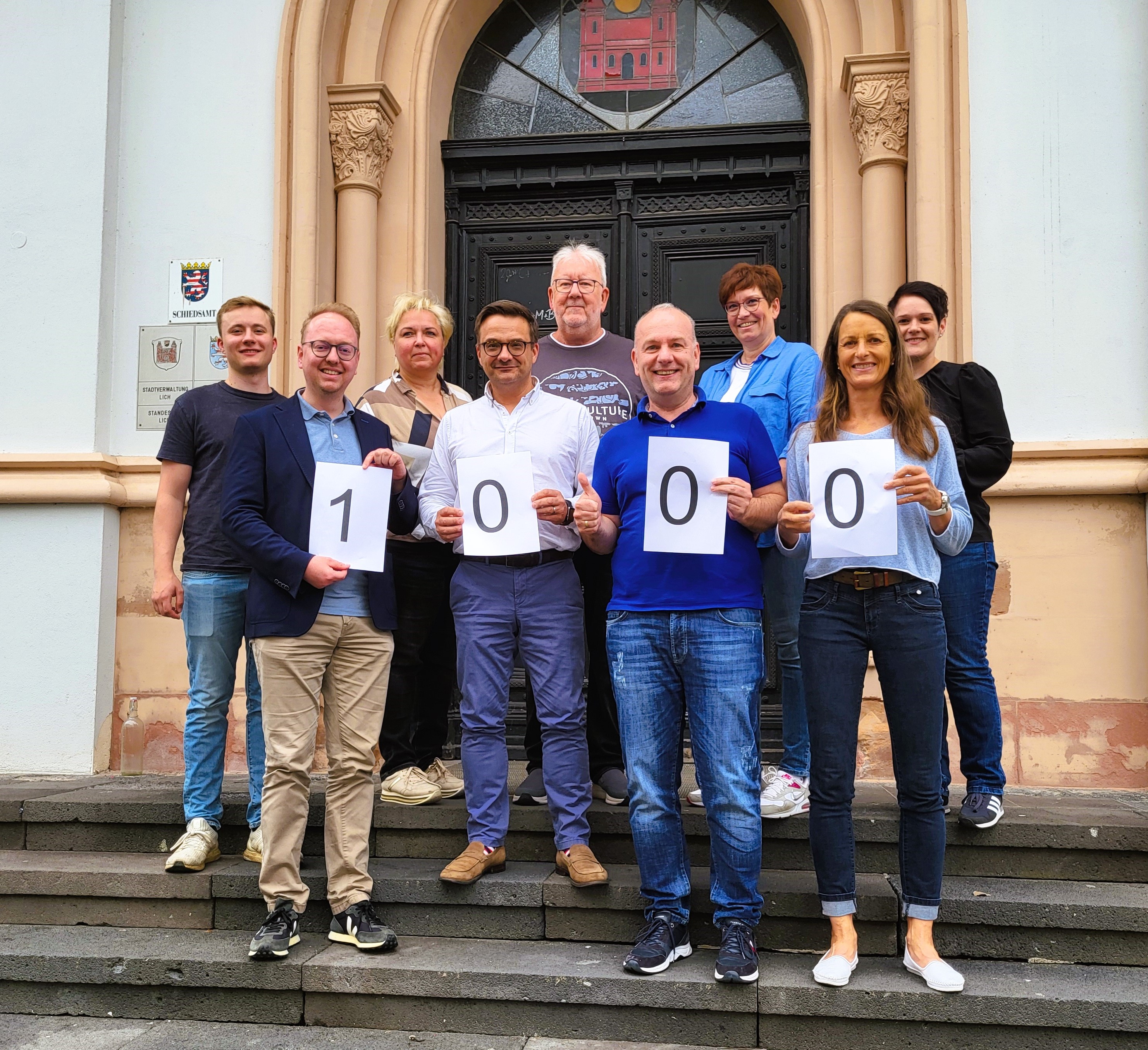 Die stimmberechtigten Mitglieder des Beteiligungsbeirats mit dem Bürgermeister und der Koordinatorin vor dem Haupteingang des Rathauses